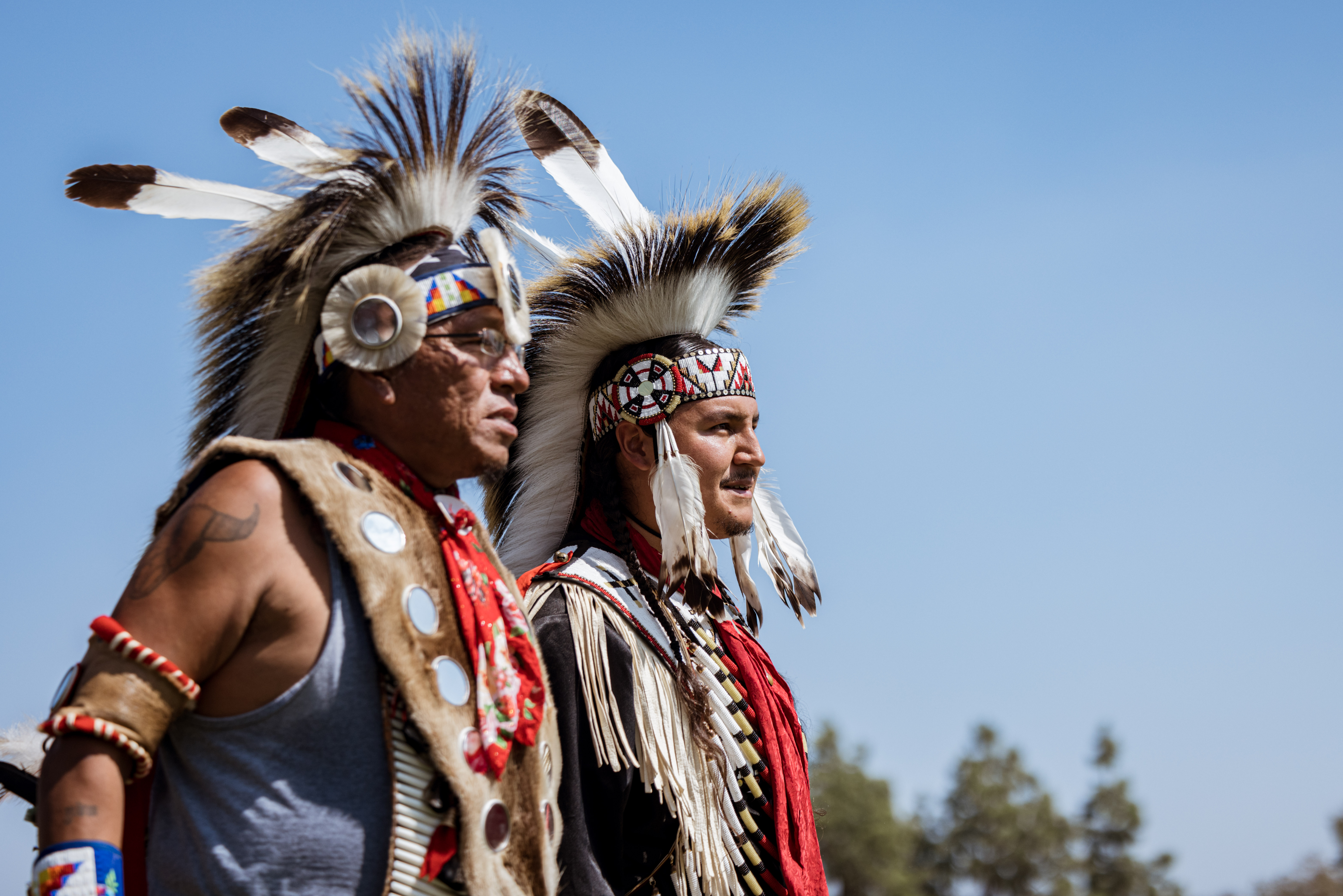 Native men wearing traditional regalia